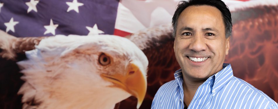 Man beside eagle and American flag